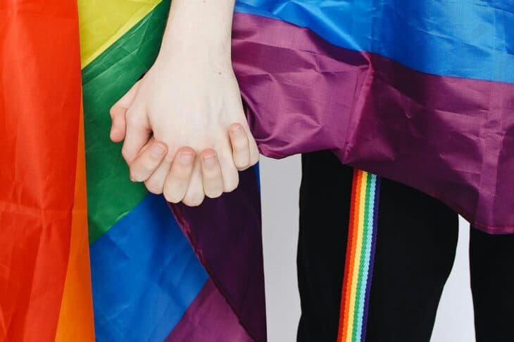 Holding hands with pride flag